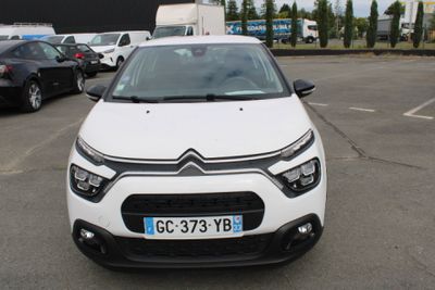 une Citroën blanche garée sur un parking