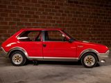 a red car that is parked in front of a brick wall