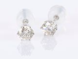 une paire de boucles d'oreilles en diamant posées sur une surface blanche
