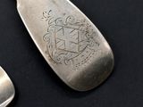 a silver spoon and a silver spoon with a crest on it