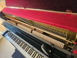 a piano with a case on top of it in a room