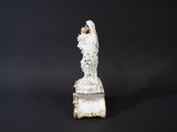 a white statue of an angel on a pedestal against a black background