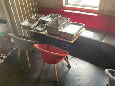 une table avec une chaise rouge et une chaise rouge devant une table sur laquelle se trouvent des plats