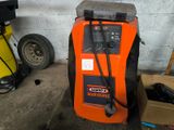 an orange machine that is sitting in a garage