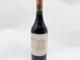 une vieille bouteille de vin posée sur une surface blanche