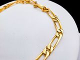 the gold chain bracelet is on display on a mannequin