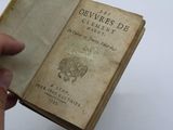 someone is holding an old book in their hand on a white surface