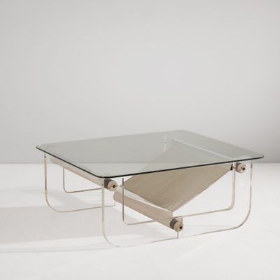 une table basse en verre avec des pieds en métal et un plateau carré en verre
