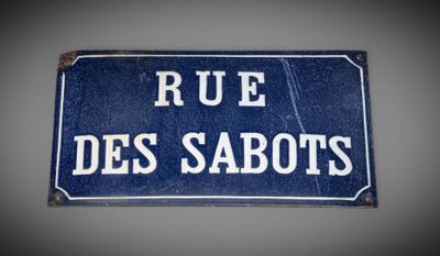 blue sign with white writing on it saying rue des sabotts