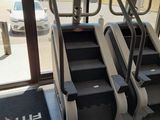 three tread machines in a gym room with a view of a parking lot