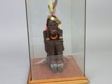 a glass display case with a figurine of an indian man