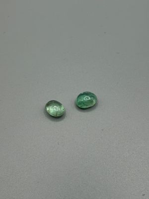 deux perles de verre vertes posées sur une table