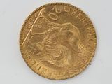 a close up of a gold coin on a white surface
