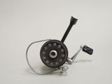 a close up of a fishing reel on a white surface