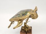 brass figurine of a turtle on a wooden block