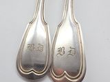 two silver spoons with chinese writing on them