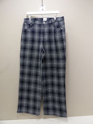 un gros plan sur un pantalon à carreaux suspendu à un mur