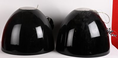 deux casques noirs posés l'un à côté de l'autre sur une surface blanche