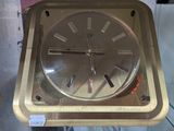 une horloge en or posée sur un socle en métal