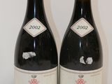 deux bouteilles de vin posées sur une table l'une à côté de l'autre