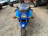 a blue motorcycle that is parked in a parking lot