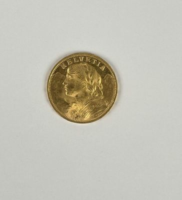 gros plan d'une pièce d'or sur une surface blanche