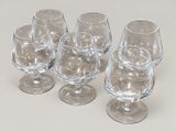 quatre verres à vin vides posés sur une surface blanche
