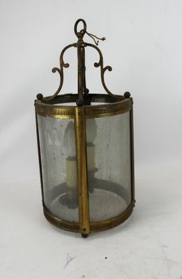 an old fashioned brass lantern with a candle inside of it