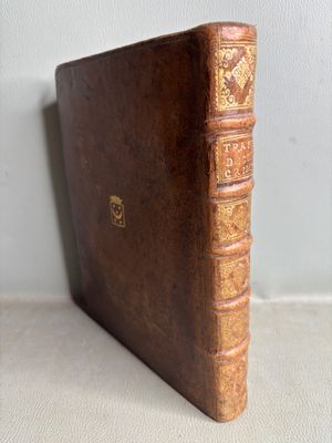 an old brown book sitting on top of a table next to a white wall
