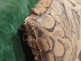 a close up of a green couch with a pillow on it