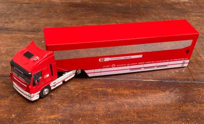 un camion miniature posé à côté d'une boîte sur une table