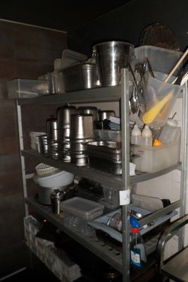 une étagère en métal sur laquelle sont posés des casseroles et des poêles