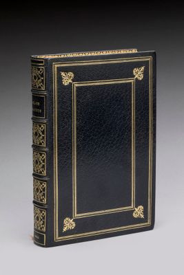 un livre noir avec des finitions dorées et une bordure dorée