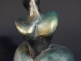an image of a sculpture of a woman sitting on top of a rock