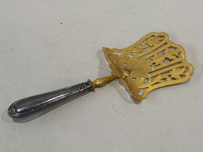 a silver spoon with a gold handle on a white surface