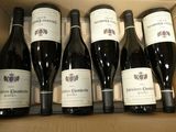 six bouteilles de vin dans un carton sur la table