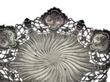 a silver plate with a design on it on a white background