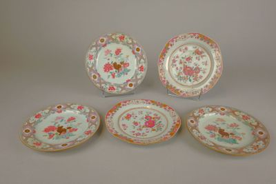 quatre assiettes ornées de motifs floraux et d'une bordure dorée sur fond blanc