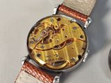 a close up of a watch on a white surface