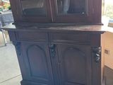 a china cabinet that has a glass door on it