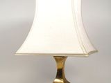 lampe de table en laiton avec un abat-jour blanc sur fond blanc