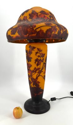 a lamp that is sitting on a table next to an apple