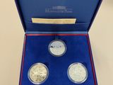 a blue box with three silver coins in it on a table