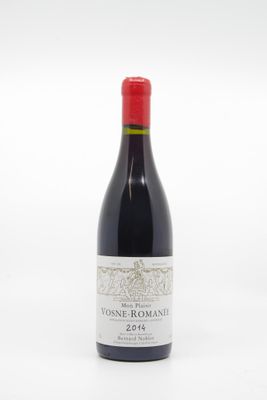 une bouteille de vin posée sur une table blanche