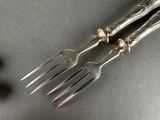 two forks that are sitting next to each other on a table