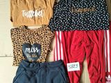 three pairs of clothes on a cardboard box with a price tag
