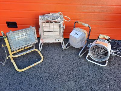 three portable heaters sitting next to each other in front of an orange wall
