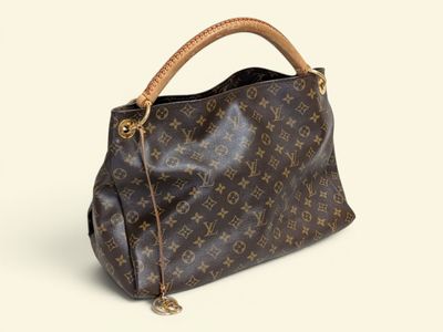 un gros plan d'un sac à main Louis Vuitton posé sur une surface blanche