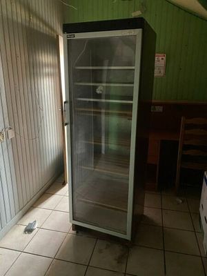 un réfrigérateur qui se trouve dans le coin d'une pièce