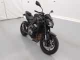 une moto noire garée dans une pièce blanche